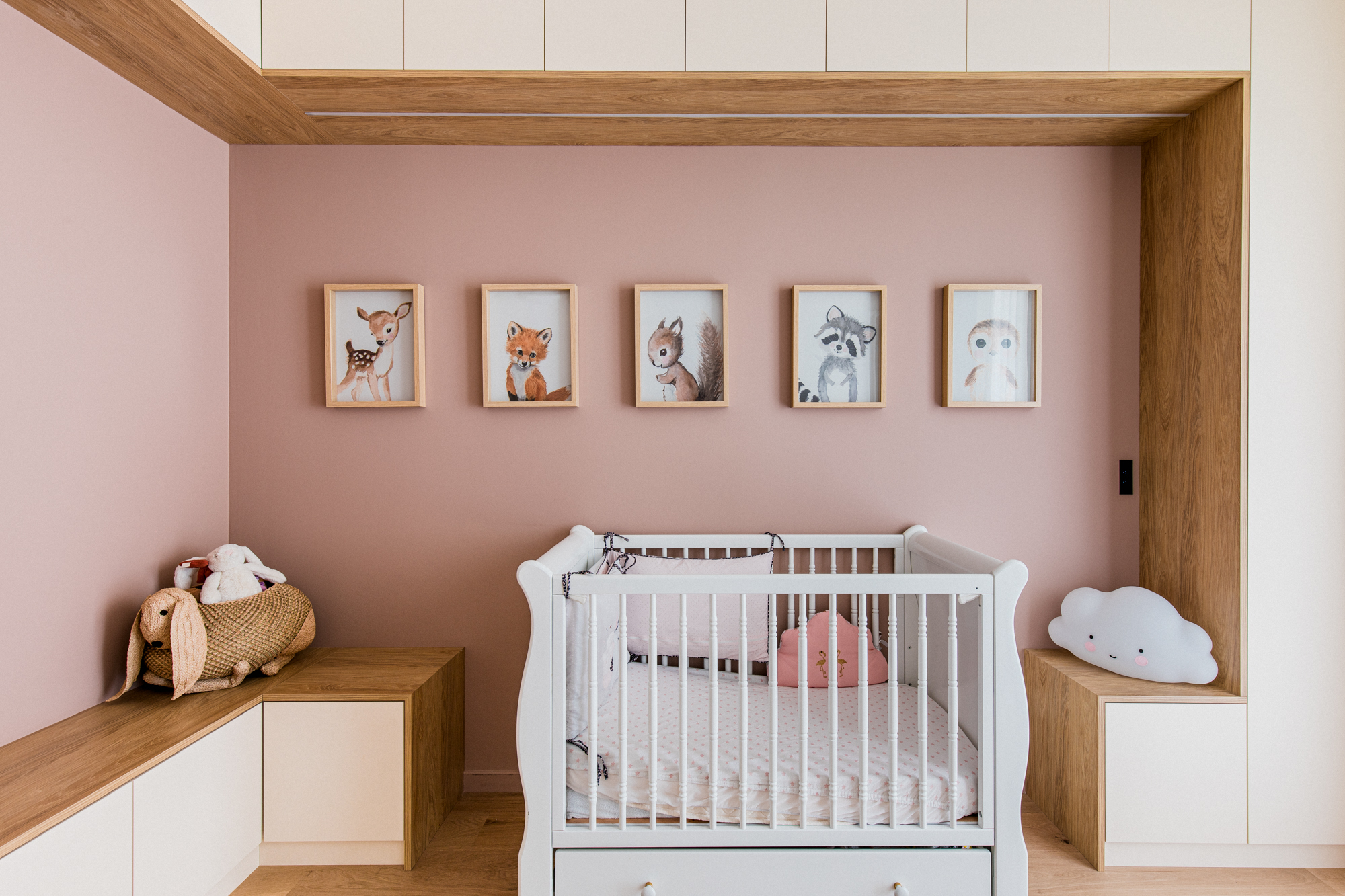 Photo d'une chambre d'enfant rose bébé avec cadres de personnages